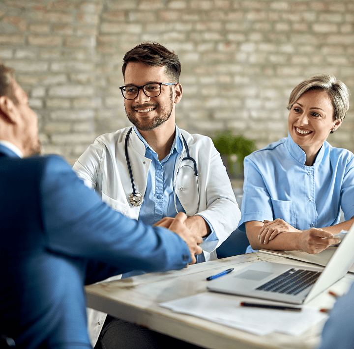 Man in suit shaking hands with doctor,