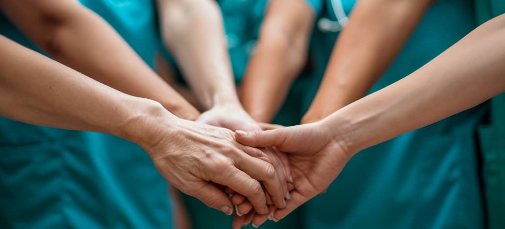 Close-up of nurses holding hands